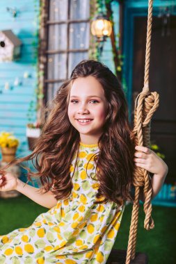 Mutlu çocuk çocuk salıncak ve gülümseyerek poz