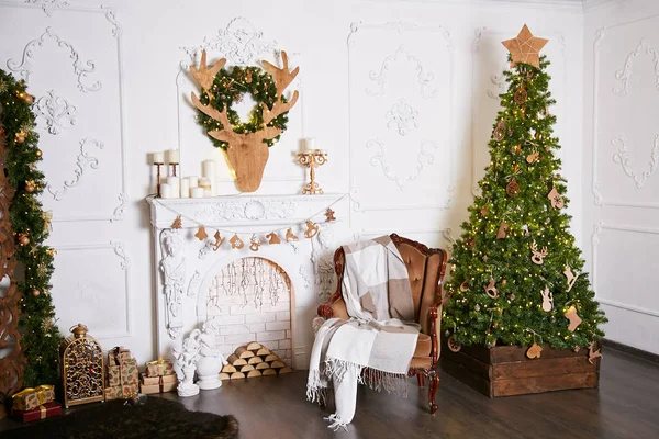 L'interno è in stile classico, decorato con decorazioni natalizie. Pareti bianche con stucchi e pietra artificiale. Albero di Natale alto decorato con una ghirlanda — Foto Stock