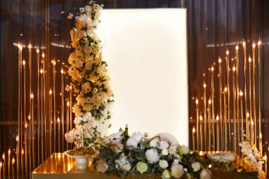 Altın renkli yeni evlilerin düğün masası. Dekoratif unsurlar ve masada taze beyaz çiçek bir buket. Vintage lambalar Çelenk.