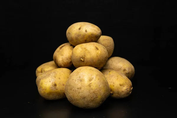 黑色背景上的土豆一堆土豆 — 图库照片