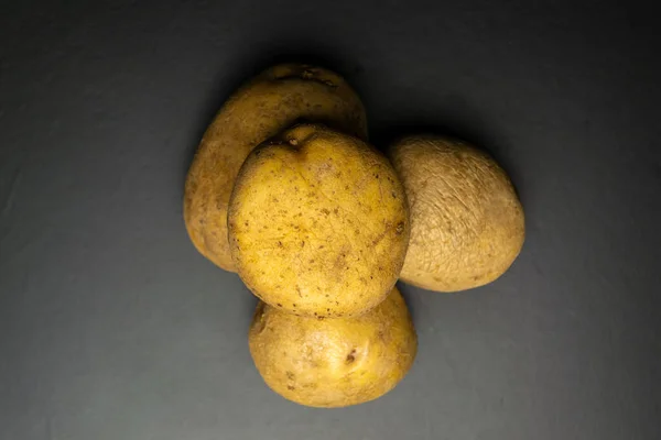 黒い背景のジャガイモジャガイモの束 — ストック写真