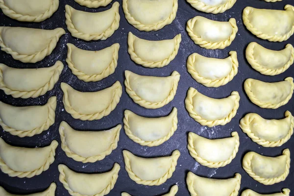 Siyah arka planda un serpiştirilmiş hamur tatlısı.