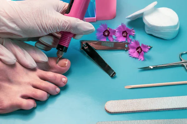 Preparing nails for applying gel polish. Set of cosmetic tools for manicure and pedicure on a black background. Gel polishes, nail files and tongs and a lamp.