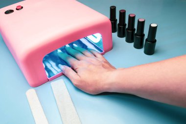 Jel cilasıyla yapılan manikür işlemi. Ultraviyole lambayı teslim et, jel cilası kurudu..