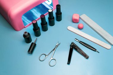 Jel cilasıyla yapılan manikür işlemi. Mavi arkaplan.