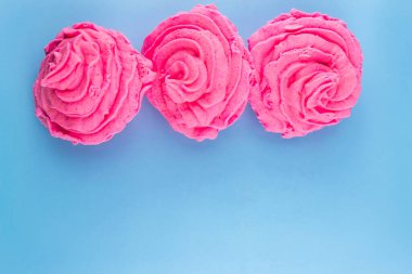 Mavi bir zemin üzerinde pembe tatlı hava şekerlemesi leziz bir tatlı.