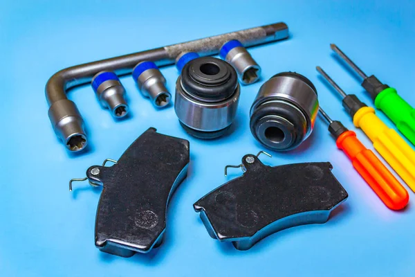 Auto parts, brake discs, pads. Salintblok car, starry auto keys, brake pads and screwdrivers on a blue background