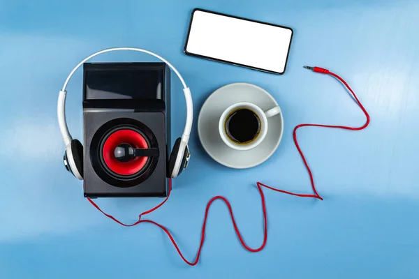 Coluna Fones Ouvido Smartphone Uma Xícara Café Fundo Azul Close — Fotografia de Stock