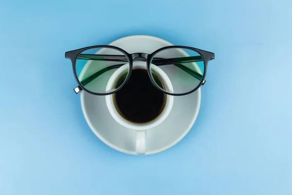 Šálek Kávy Brýle Černými Obroučkami Modré Pozadí — Stock fotografie