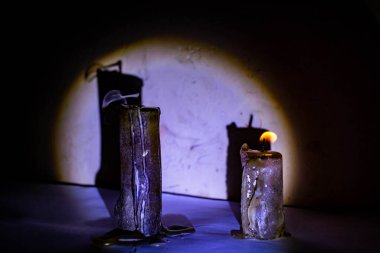 Alacakaranlık bağbozumunda arka planda gölgesi olan iki mum.