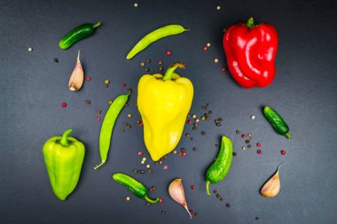 Üç farklı renkte biber, sarımsak, salatalık. Siyah arkaplan