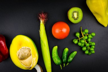 Mangolu mısır salatalığı domatesli kivi üzümü biberi. Siyah arkaplan