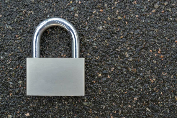 Locked metallic padlock on the gray background.