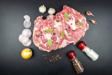 Değirmende biber ve tuzun yanında büyük bir parça taze çiğ et. Siyah arkaplan