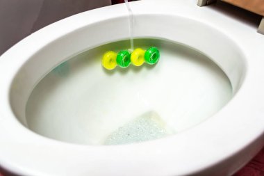 Çok renkli tuvalet parfümleri tuvalete yapışmış.