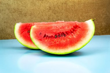 Taze kırmızı karpuz dilimlerinin yakın çekimi. Mavi arkaplan