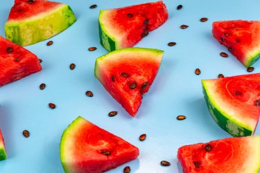 Mavi arka planda karpuz dilimleri ve karpuz tohumlarının üst görüntüsü