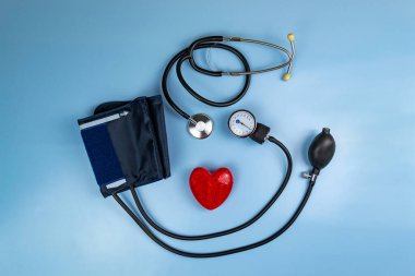 Kırmızı kalp ve steteskop mavi arka planda. Tıbbi bakım konsepti ve kopyalama alanı. Hastalıkların tedavisi için mavi arka planda tıbbi ekipman görüntüsü.