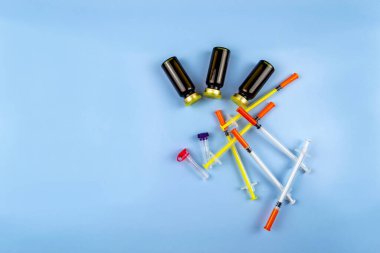 Mavi arka planda insülin ve şırıngalar. Dünya Diyabet Günü