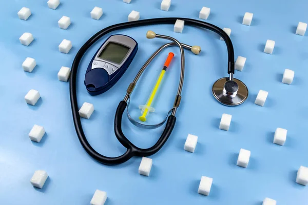 デジタル血糖値計砂糖キューブに囲まれた聴診器 世界糖尿病デー — ストック写真