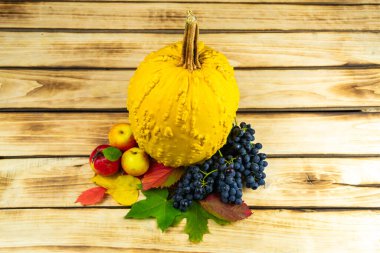 Balkabağı, sonbahar yaprakları, üzümler ve elmalar ahşap bir zeminde. Şükran Günü. Sonbahar temalı arkaplan.