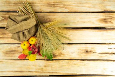 Elma, bir demet buğday ve ahşap zemin üzerinde bir torba buğday. Şükran Günü. Sonbahar temalı arkaplan.