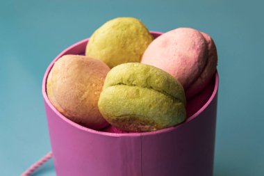 Mavi arka planda badem kurabiyesi olan şenlikli pembe kutu. Sevgililer Günü. Yakın plan, kopyalama alanı