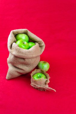 Kırmızı arka planda yeşil elmalar. Yakın plan.