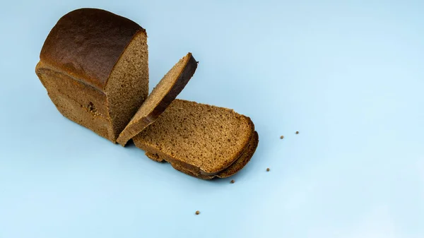 Pół Bochenka Chleba Żytniego Plasterkach Zbliżenie Niebieskim Tle — Zdjęcie stockowe