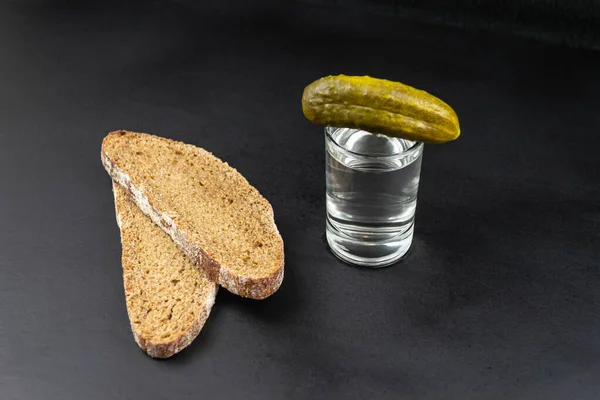 Marynowany Ogórek Kieliszku Wódką Dwa Kawałki Czarnego Chleba Czarnym Tle — Zdjęcie stockowe