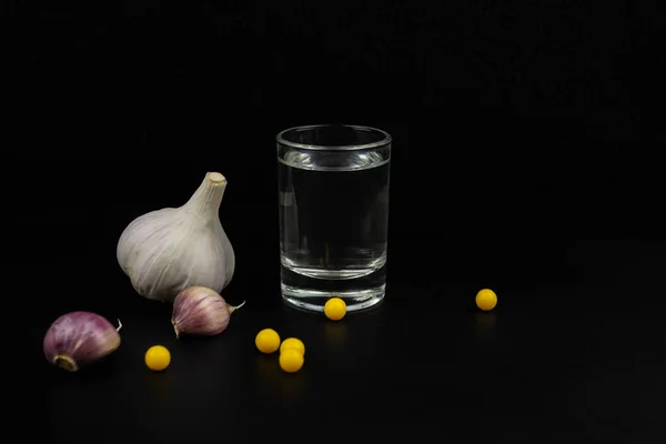 Glas Wodka Knoblauch Und Vitamine Auf Schwarzem Hintergrund — Stockfoto