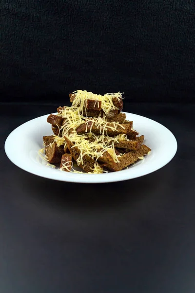 Homemade black bread croutons with garlic and cheese on a black background — Stock Image Homemade Black Bread Croutons Garlic Cheese Black Background Stock Picture
