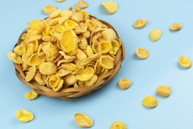 Kahverengi hasır kaplamalı mısır gevrekleri mavi arka planda kapanıyor.