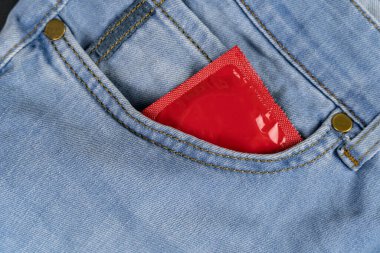 Kot pantolonun cebinde kırmızı prezervatif