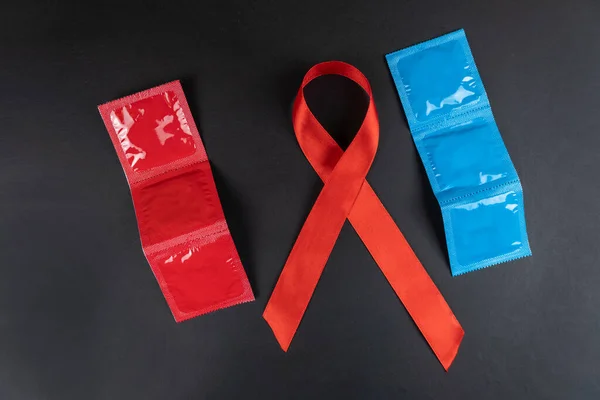 Veelkleurige Condooms Rood Lint Aids Dag Zwarte Achtergrond — Stockfoto