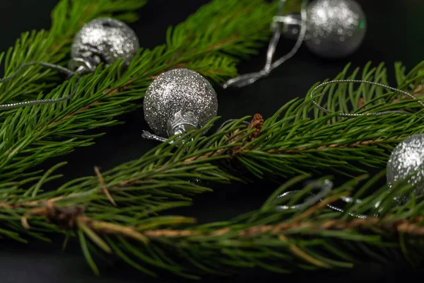 Fir Takken Zijn Versierd Met Nieuwjaarsspeelgoed Een Zwarte Achtergrond Kerstmis — Stockfoto