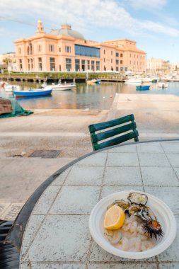 Taze balık, deniz kestanesi, istiridye, mürekkep balığı, ahtapot limon ile Aziz Nikolaos iskele bölgesinin Bari, Puglia, İtalya şehir merkezinde piyasaya yakaladı.