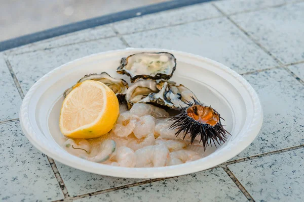 Nyfångad fisk, sjöborre, ostron, bläckfisk, bläckfisk med citron på marknaden på piren av St Nicholas i centrala Bari, Apulien, Italien. — Stockfoto