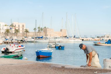 Bari, Puglia, İtalya - 07 Kasım, 2018: balıkçı üzerinde taze ahtapot yener St. Nicholas iskele bölgesinin Bari, Puglia, İtalya şehir merkezinde. liman ve deniz araçları.