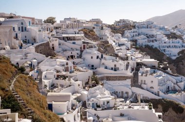 Santorini, Yunanistan. Önünde çiçekler olan küçük caddedeki geleneksel Kiklad Santorini evlerinin resimli görüntüsü. Konum: Oia Köyü, Santorini, Yunanistan. Tatil arkaplanı.