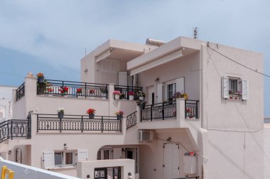 Santorini, Yunanistan. Önünde çiçekler olan küçük caddedeki geleneksel Kiklad Santorini evlerinin resimli görüntüsü. Konum: Oia Köyü, Santorini, Yunanistan. Tatil arkaplanı.