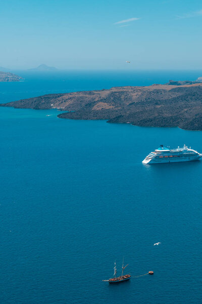 Санторини, Греция. Живописный вид на традиционные кикладические дома Санторини на небольшой улочке с цветами на переднем плане. Локация: деревня Оя, Санторини, Греция. Отдых
.