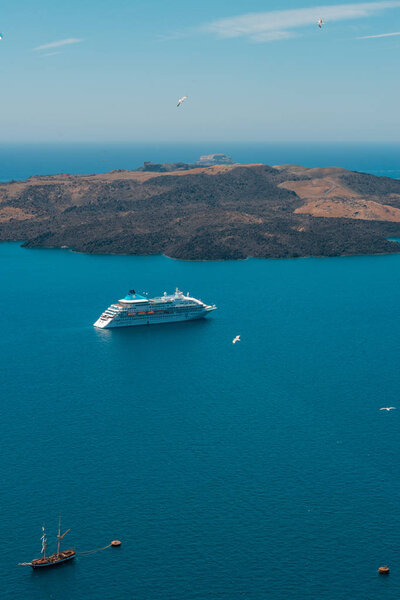 Санторини, Греция. Живописный вид на традиционные кикладические дома Санторини на небольшой улочке с цветами на переднем плане. Локация: деревня Оя, Санторини, Греция. Отдых
.