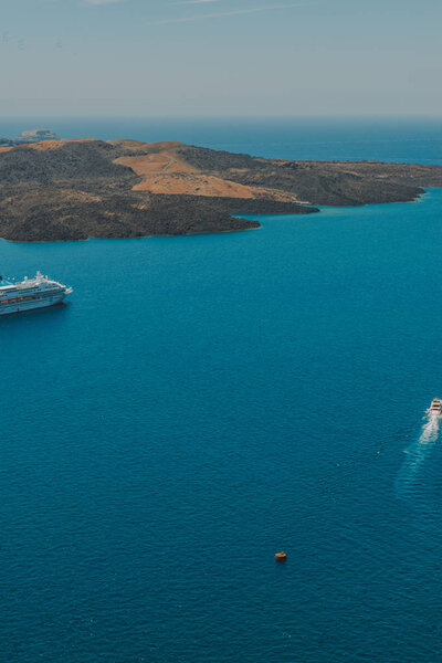Санторини, Греция. Живописный вид на традиционные кикладические дома Санторини на небольшой улочке с цветами на переднем плане. Локация: деревня Оя, Санторини, Греция. Отдых
.