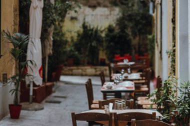 Bardaklı bir masa, beyaz masa örtüsü ve sokak kafesinde peçeteler. Seçici odak.