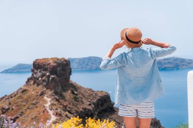 Santorini Oia 'da tatilde olan turist bir kadın merdivenlerde yürüyor. Beyaz elbiseli kişi Akdeniz ve mavi kubbeleri olan ünlü beyaz köyü ziyaret ediyor. Avrupa yaz gezisi