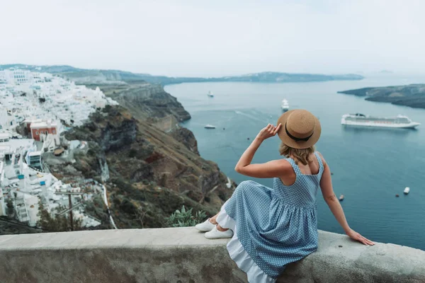 Utazz Európába nyaralni. Portré gyönyörű nő látogató régi falu Oia, Santorini sziget, Görögország napsapka és nyári ruha. — Stock Fotó