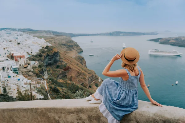 Viaje por Europa durante las vacaciones de verano. Retrato de la bella mujer que visita el casco antiguo de Oia, isla Santorini, Grecia con sombrero de sol y vestido de verano.. — Foto de Stock