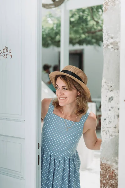 Reis door Europa voor zomervakantie. Portret van een mooie vrouw die Oia bezoekt, Santorini eiland, Griekenland met zonnehoed en zomerjurk. — Stockfoto