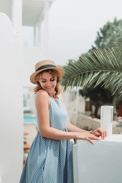 Reis door Europa voor zomervakantie. Portret van een mooie vrouw die Oia bezoekt, Santorini eiland, Griekenland met zonnehoed en zomerjurk. — Stockfoto